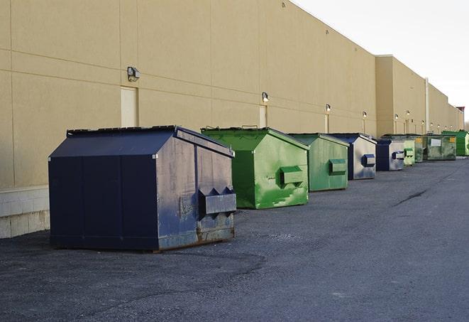 a fleet of red and blue construction dumpsters available for use in Huntsville UT